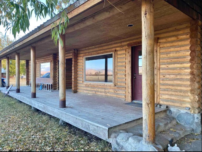 A empty porch on a wooded building at East Side Mountain View Cabin.