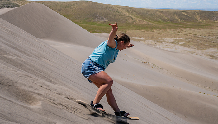 Sand Boarder at Bruneau Dunes State Park. Woman Sandboarding at an Idaho State Park with Sand Dunes. 