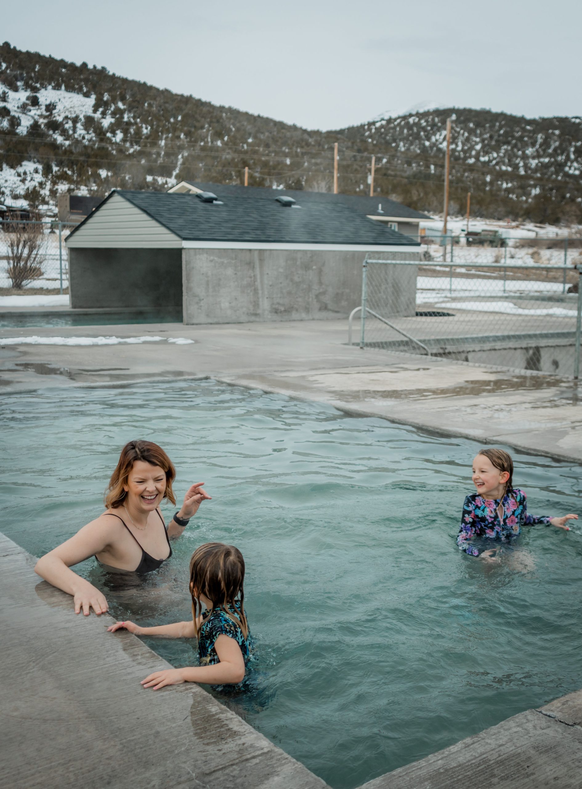 A woman and two children soaking in a commercial hot spring.