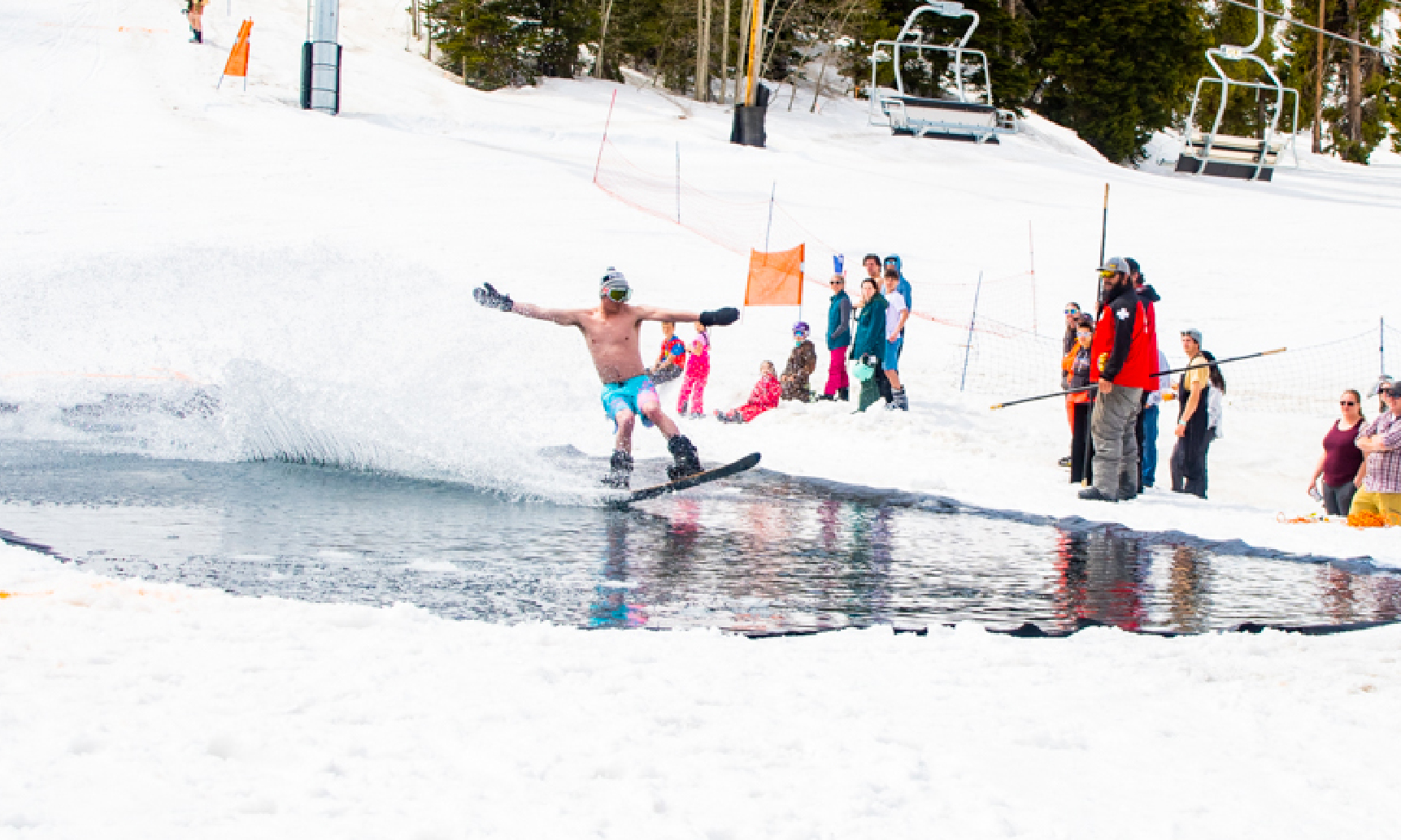 Man water skiing in water surrounded by snow