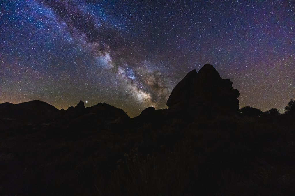 The night sky filled with stars over the silhouettes of the rocky landscapes of Little City of Rocks.