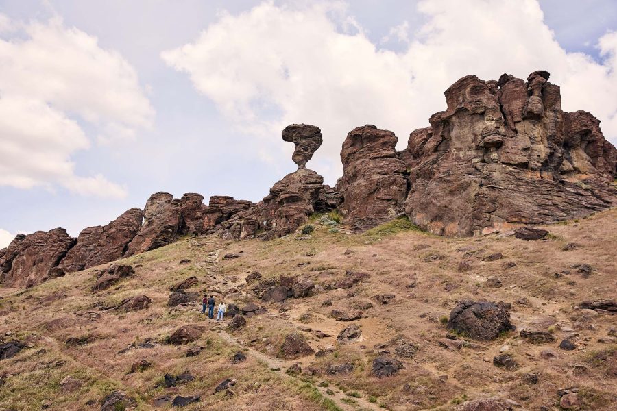 Hikers admire a rock formation known as Balanced Rock in Idaho.