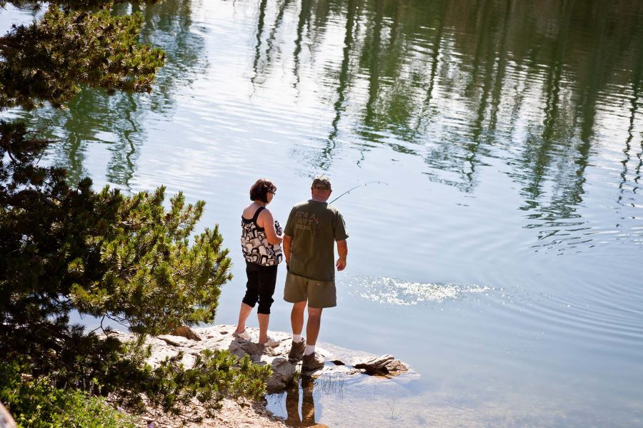 Two people fishing on the shore of Centennial Waterfront Park in Twin Falls, Idaho. 